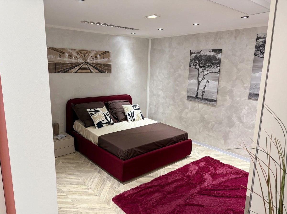 Schlafzimmerausstellung mit Bett, Teppich und Wandbildern