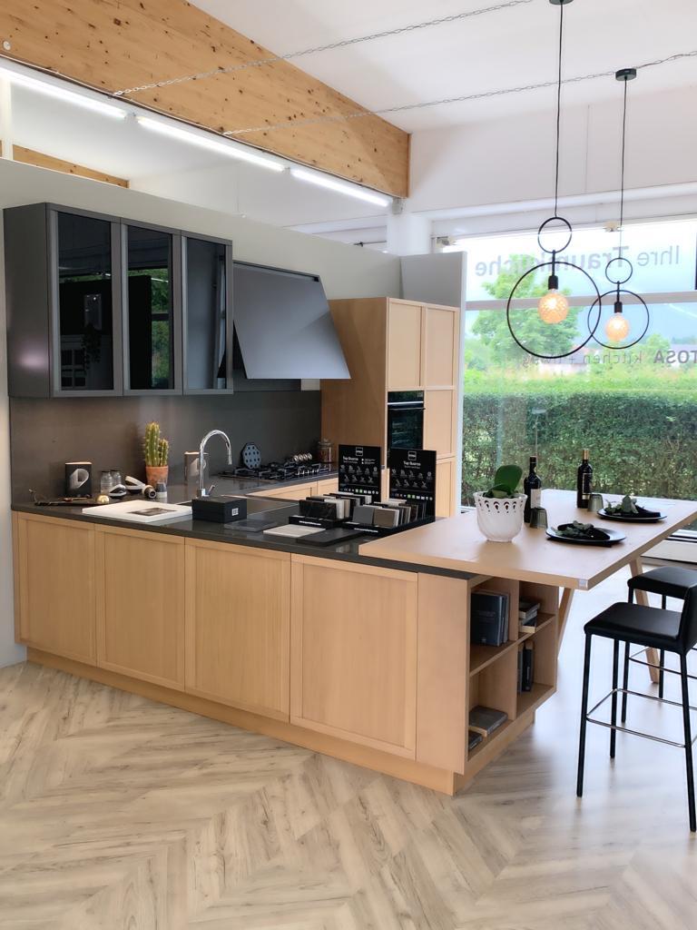 L-förmige Kücheninsel mit Holztresen, zwei Ringleuchten und Materialmustern